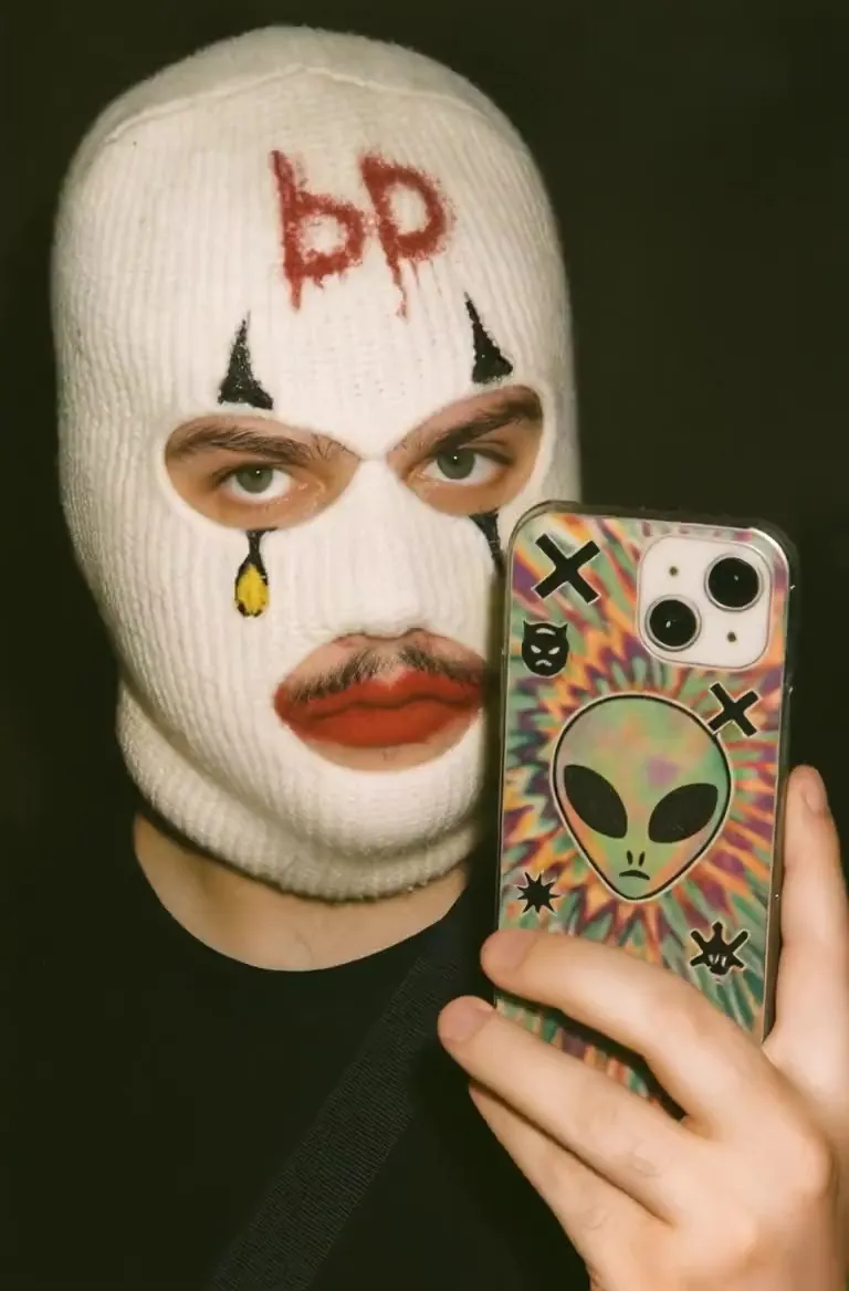 A masked clown face taking a selfie
